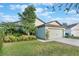 House exterior showcasing landscaping and a two-car garage with light green siding at 2334 Bexley Dr, Tavares, FL 32778