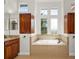 Elegant bathroom with granite countertop and soaking tub at 2441 Bar Harbor Bay, Mount Dora, FL 32757