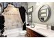 Guest bathroom with a tub, double vanity, and decorative mirror at 2532 Edenville Path, The Villages, FL 32162