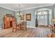 Bright dining room with wood table and chairs, hardwood floors, and access to the entryway at 2532 Edenville Path, The Villages, FL 32162