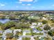 An aerial view of a suburban neighborhood featuring a lake, mature trees, and well-maintained homes at 25941 Newcombe Cir, Leesburg, FL 34748