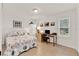 Bedroom with seashell-themed bedspread, desk and a view to the outdoors at 25941 Newcombe Cir, Leesburg, FL 34748