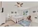 Bedroom with white furnishings, a ceiling fan, neutral flooring and a view to the outdoors at 25941 Newcombe Cir, Leesburg, FL 34748