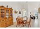 Dining room with chandelier, wooden table and chairs, cabinet, and view to the living area at 25941 Newcombe Cir, Leesburg, FL 34748