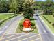 Community entrance features manicured landscaping, elegant signage, and a welcoming fountain, enhancing curb appeal at 25941 Newcombe Cir, Leesburg, FL 34748