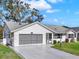 Inviting single-story home featuring a convenient screened garage and mature landscaping at 25941 Newcombe Cir, Leesburg, FL 34748