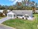 Desirable single-story home with a green lawn, screened garage, and attractive landscaping at 25941 Newcombe Cir, Leesburg, FL 34748