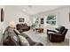 Sunlit living room showcases neutral tile floors, large windows, and comfortable seating at 25941 Newcombe Cir, Leesburg, FL 34748