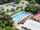 Aerial view of the community swimming pool surrounded by lounge chairs, tables, and manicured landscaping at 25941 Newcombe Cir, Leesburg, FL 34748