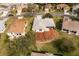 Aerial view of the property with lush landscaping and a sunroom, located in a desirable neighborhood at 26908 Honeymoon Ave, Leesburg, FL 34748