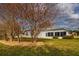 Backyard of home boasts well-maintained lawn, mature landscaping, and an inviting sunroom at 26908 Honeymoon Ave, Leesburg, FL 34748
