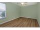 Secondary bedroom with light green walls and hardwood floors at 26908 Honeymoon Ave, Leesburg, FL 34748