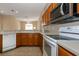 View of kitchen with wood cabinets, white appliances and a breakfast bar at 26908 Honeymoon Ave, Leesburg, FL 34748