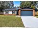 Exterior view of a charming ranch-style home with a brick facade and attached garage at 2725 Lakewood Ln, Eustis, FL 32726