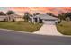 Single-story house with a red door and attached garage, aerial sunset view at 27302 Orchid Glade St, Leesburg, FL 34748