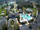 Aerial view shows community clubhouse, pool, and tennis courts at 27302 Orchid Glade St, Leesburg, FL 34748