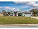 Single-story home with gray exterior, red door, and two-car garage at 27302 Orchid Glade St, Leesburg, FL 34748