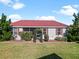 House exterior with red roof and landscaped yard at 2762 Morven Park Way, The Villages, FL 32162