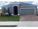 Gray house with two-car garage and landscaped yard at 2848 Supermarine Rd, Tavares, FL 32778