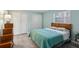 Main bedroom with wood flooring and teal bedding at 312 Brigadoon Cir # 312, Leesburg, FL 34788