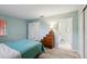 Bedroom with teal bedding, wood flooring, and access to bathroom at 312 Brigadoon Cir # 312, Leesburg, FL 34788