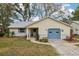 Cute yellow house with blue garage door, landscaped lawn, and walkway at 312 Brigadoon Cir # 312, Leesburg, FL 34788