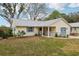 Quaint yellow house with blue garage door and lush green lawn at 312 Brigadoon Cir # 312, Leesburg, FL 34788