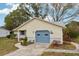 House exterior showcasing a yellow facade, blue garage door, and neat landscaping at 312 Brigadoon Cir # 312, Leesburg, FL 34788