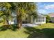 Screened lanai and lush green lawn with palm trees at 3488 Sterling St, The Villages, FL 32162