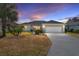 House exterior at dusk showcasing a single story home with landscaping and driveway at 3488 Sterling St, The Villages, FL 32162