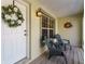 Front porch with seating area and a decorative wreath on the door at 3488 Sterling St, The Villages, FL 32162