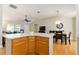 Kitchen island with wood cabinets and a view into the dining area at 3488 Sterling St, The Villages, FL 32162