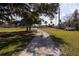 Long driveway leading to property, with mature oak trees and lush green grass at 3704 Warm Springs Ave, Wildwood, FL 34785