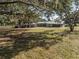 Ranch home with carport and expansive yard, nestled amongst mature trees at 3704 Warm Springs Ave, Wildwood, FL 34785