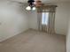 Bright bedroom featuring ceiling fan, window, and neutral carpeting at 403 W Palm Ave, Bushnell, FL 33513