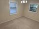 Bright bedroom with neutral carpeting and two windows at 403 W Palm Ave, Bushnell, FL 33513