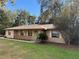 Tan one-story house with brown roof, stone accents, and a covered porch at 403 W Palm Ave, Bushnell, FL 33513