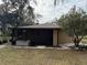 Rear view of house with screened porch and hot tub at 403 W Palm Ave, Bushnell, FL 33513