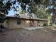 Rear view of tan house with double doors and patio at 403 W Palm Ave, Bushnell, FL 33513