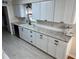 Modern kitchen featuring white shaker cabinets, granite countertops, and tile flooring at 403 W Palm Ave, Bushnell, FL 33513