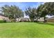 Large backyard with lush lawn and mature trees at 4077 Greystone Dr, Clermont, FL 34711