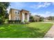 Two-story house with tan exterior, lush lawn, and attached garage at 4077 Greystone Dr, Clermont, FL 34711