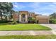 Tan two-story house with a large front yard and a three-car garage at 4077 Greystone Dr, Clermont, FL 34711