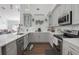 Modern kitchen with gray cabinets, stainless steel appliances, and white countertops at 415 Renee Dr, Haines City, FL 33844