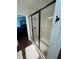 Bathroom with a white tiled shower and dark accents, with partial view of bedroom at 4556 Water Oak Ter, Oxford, FL 34484