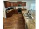 Well-lit kitchen featuring wood cabinets, granite countertops, stainless steel appliances, and hardwood floors at 4556 Water Oak Ter, Oxford, FL 34484