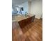 Kitchen island with seating, granite countertops, stainless steel sink, and dark wood cabinets at 4556 Water Oak Ter, Oxford, FL 34484