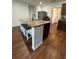 Kitchen island with seating, granite countertops, a stainless steel sink, and hardwood floors at 4556 Water Oak Ter, Oxford, FL 34484