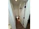 Small toilet room with a white toilet, door with hooks, and dark wood floors at 4556 Water Oak Ter, Oxford, FL 34484