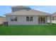 Exterior view of the home's rear facade, featuring large windows, a sliding glass door, and a spacious backyard at 5119 Firebush Dr, Apopka, FL 32712